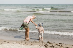 Mormor och barnbarn på strand