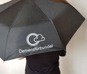 Svart paraply med vit logotyp